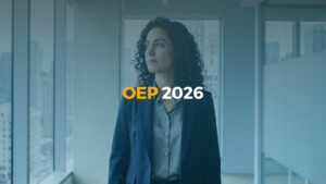 Mujer joven profesional mirando por la ventana en una oficina moderna, imagen representativa de la previsión y preparación para la OEP 2026.